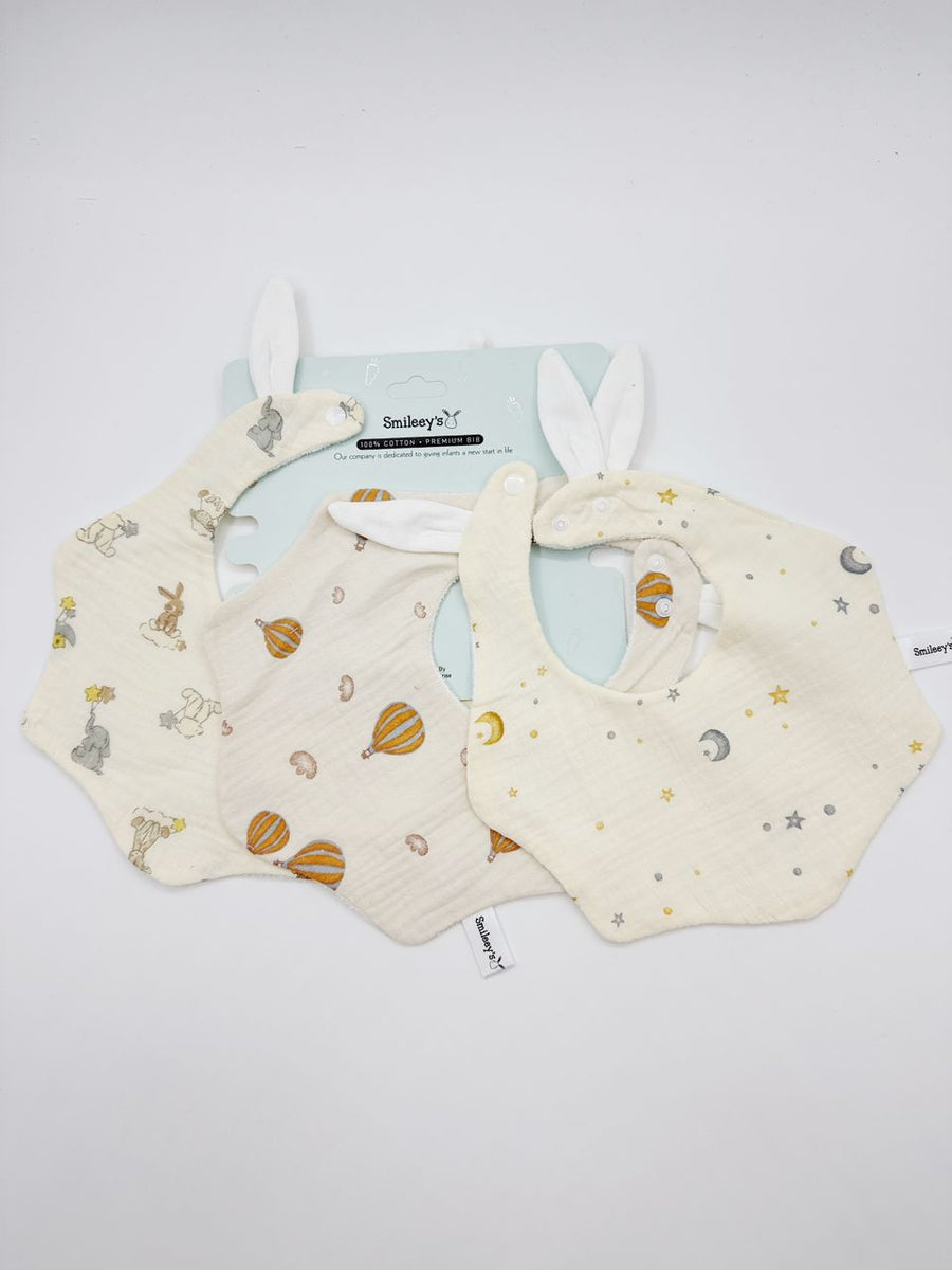 Smileey's 3pcs baby waterproof bib set - three cotton muslin bibs with bunny-ear detail in animal, hot-air balloon and star prints on a Smileey's branded card