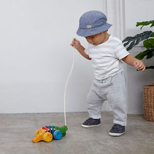 Toddler pulling the PlanToys Rainbow Alligator