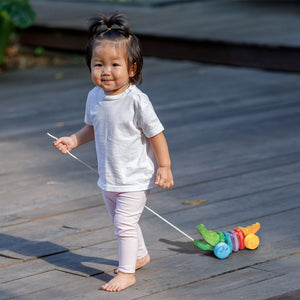 Child walking with the PlanToys Rainbow Alligator