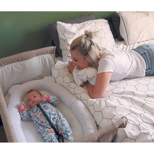 Baby sleeping in the Candide Air+ Baby Nest in a bedside cot