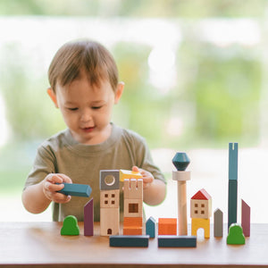 Child building a city with PlanToys Cityscape Blocks