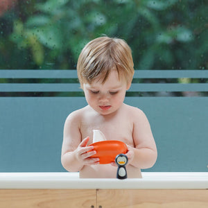 Child playing with the PlanToys Penguin Sailing Boat in the bath