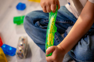 Child squeezing a bead-filled Jelly Blox block
