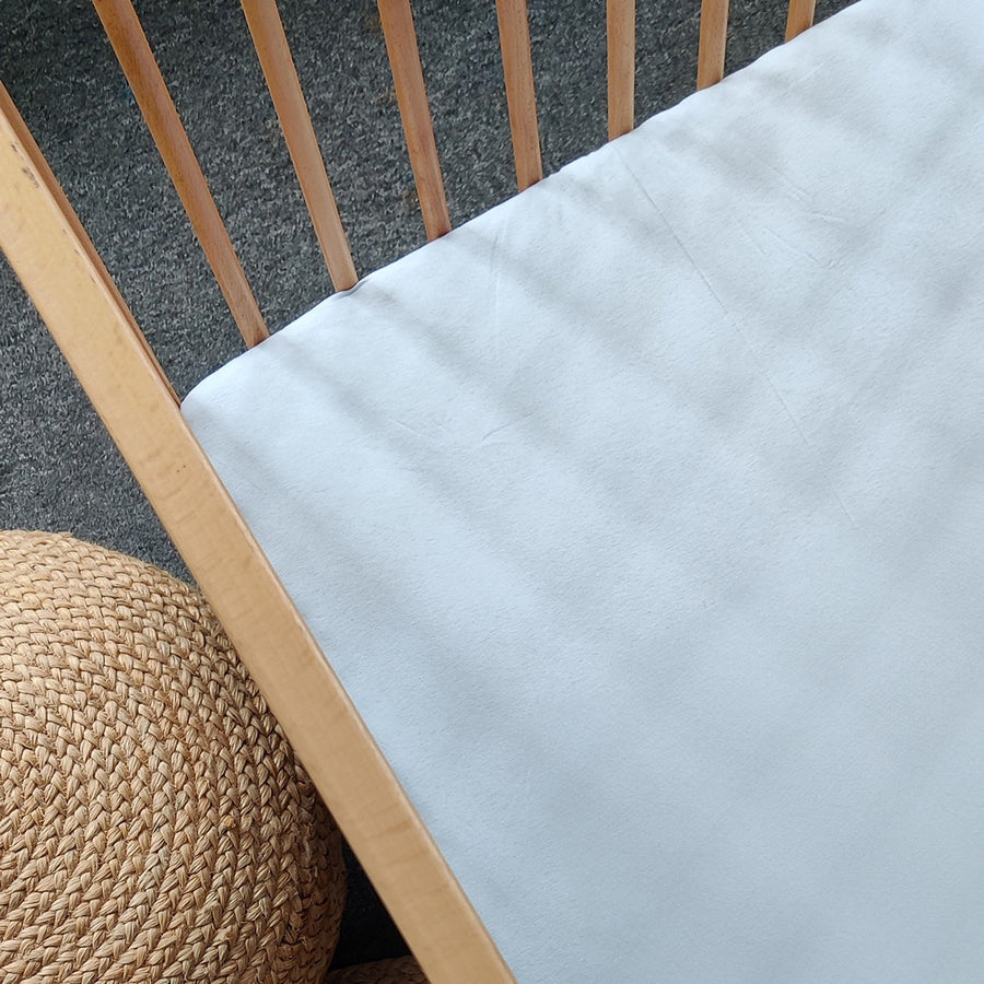 Candide cotton jersey fitted sheet 60x120 cm in sky blue on a cot mattress