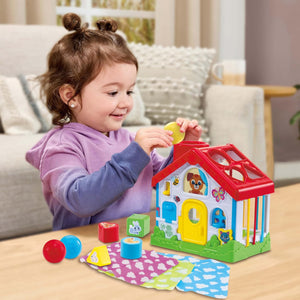 Toddler dropping a ball down the chimney of the LeapFrog Discovery House