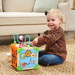 Toddler turning the gears on the LeapFrog Wooden Activity Cube
