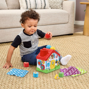 Baby playing with the LeapFrog 4-in-1 Discovery House on the floor