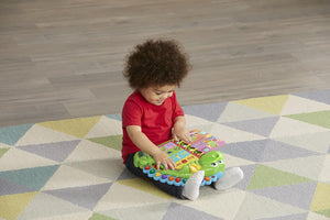 Child reading the LeapFrog Dino's Delightful Day Book on the floor