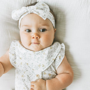 Baby wearing the Kays+Kins Wildflower Haze print bandana bib