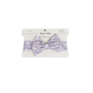 Baby wearing the Kays+Kins Twilight Blooms print pre-tied bow headband