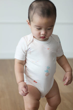 Baby wearing Twinkle Planet Circus Dino bodysuit