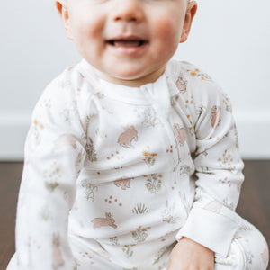 Close detail of the Springhop rabbit and meadow print on the Kays+Kins Organic Growsuit