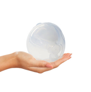 A single Freemie collection cup held in one hand to show its size