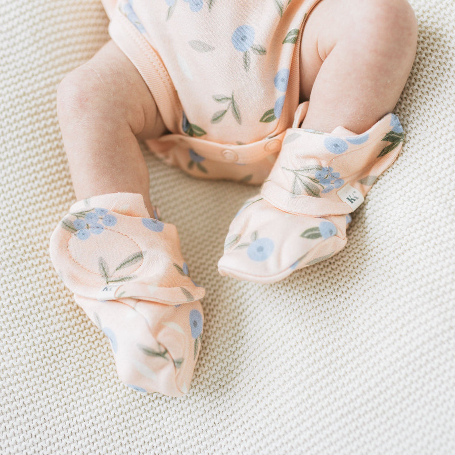 Baby wearing Kays+Kins Huckleberry print mitts and booties