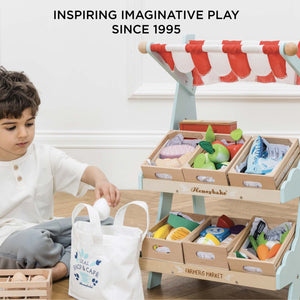 Child playing shop with Le Toy Van wooden market stall
