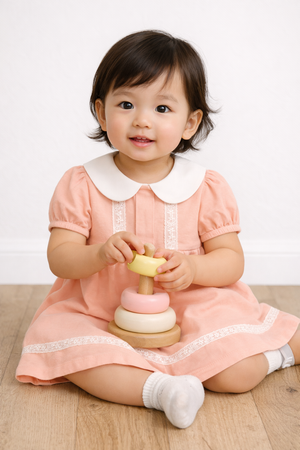 Toddler wearing Twinkle Planet Peach Pink pleated sleeve dress