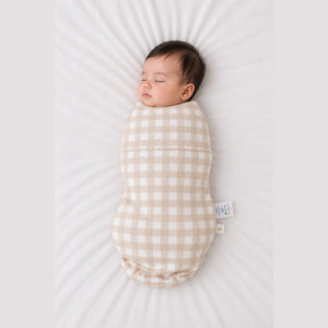 Baby sleeping in the Count & Countess Swaddle Bag, Oat Gingham