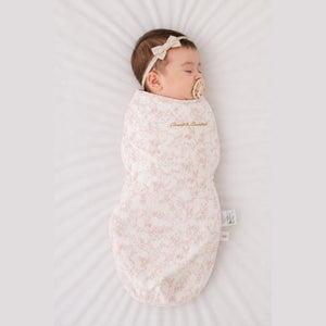 Baby sleeping in the Count & Countess Swaddle Bag, Toile De Jouy Blush