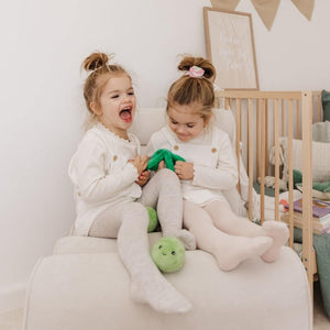 Two toddlers playing with Two Peas in a Pod plush