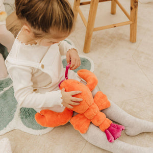 Child playing with Libby the Lobster plush