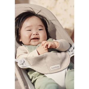 Baby resting in the BabyBjörn Bouncer Balance Soft in grey beige and white mesh