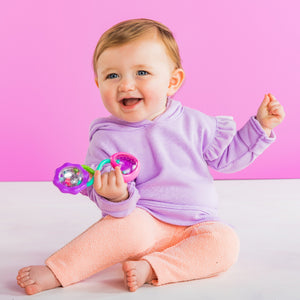 Baby holding the pink Rattle & Shake Barbell rattle