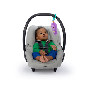 Purple sloth rattle clipped to an infant car seat handle