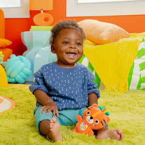 Baby playing with the tiger rattle toy