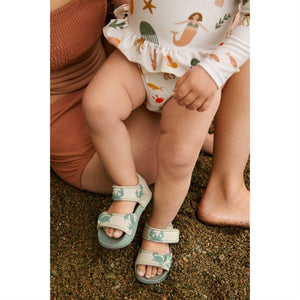 Child wearing Liewood BLUMER strap sandals in Crab / Sandy