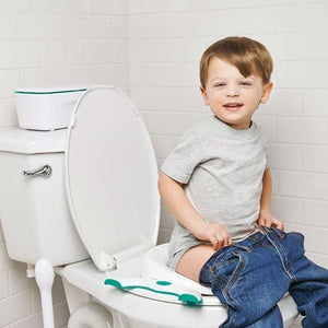 Toddler using the OXO Tot Go Potty seat on an adult toilet