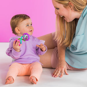 Parent playing with baby and the pink barbell rattle